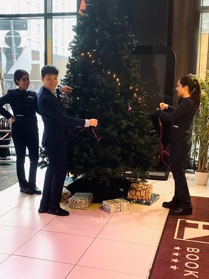 Equipo decorando el árbol de Navidad en el vestíbulo del Eurostars Book Hotel